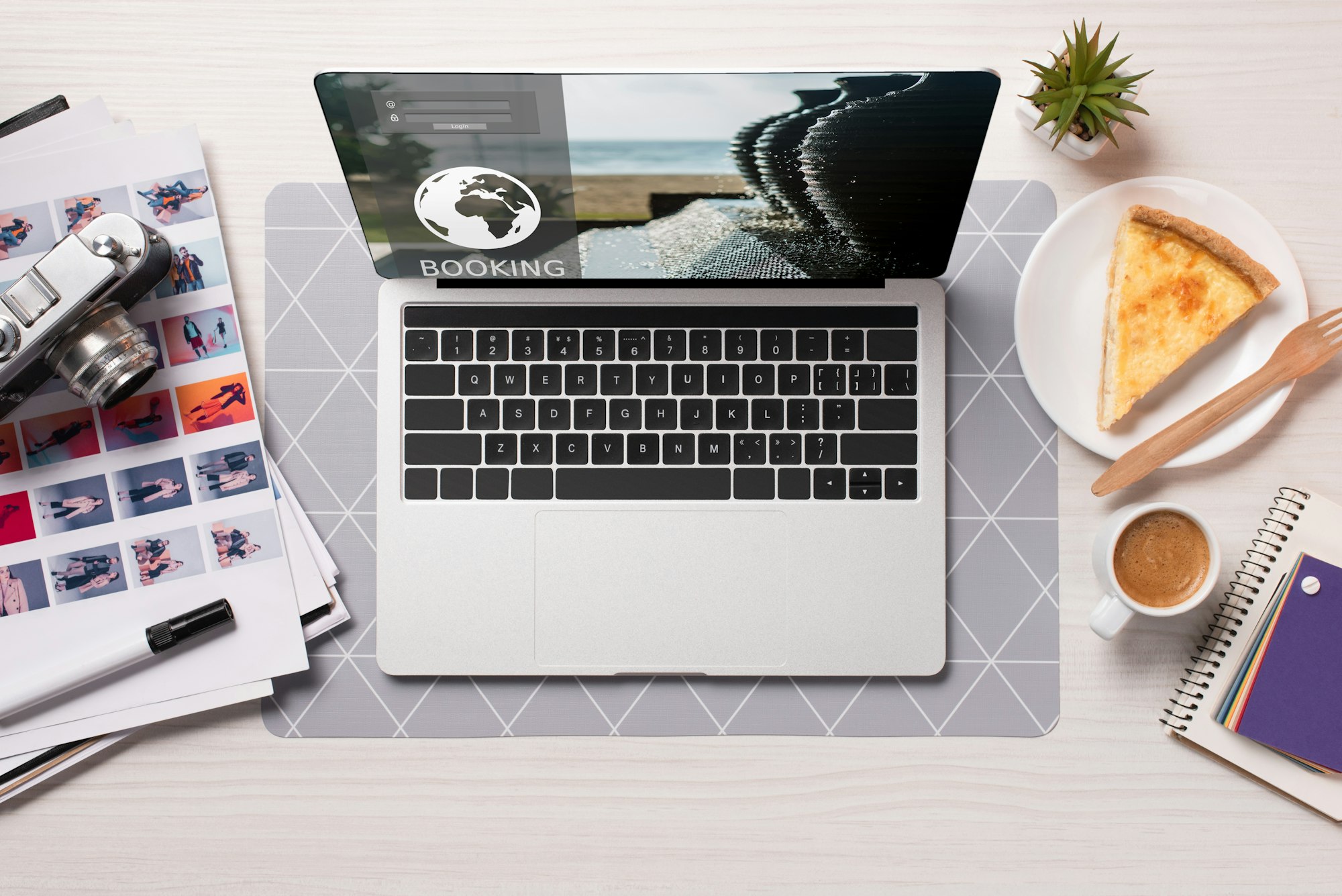 office desk with laptop with booking website on screen flat lay